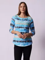 Remera de algodón con estampado floral y de rayas horizontales en tonos azules, blancos y negros. Presenta escote redondo a la base y mangas tres cuartos.