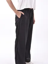 Pantalón negro de tiro alto, corte ancho y pierna recta, con cordón ajustable en la cintura.