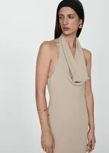 Vestido largo color beige con escote halter drapeado y espalda descubierta.
