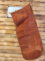 Culero con perneras de cuero marrón gamuzado, diseñado con tiras laterales para atar a la cintura.