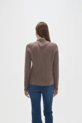 Sweater de punto con diseño de ochos, color camel, con cuello alto y mangas largas.