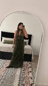 Vestido largo de terciopelo negro, con diseño al cuerpo, escote halter y pronunciado escote en V con frunce central.
