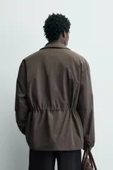 Chaquetón de corte regular fit confeccionado en tejido técnico repelente al agua, con ligero acolchado interior. Presenta cuello solapa, cierre frontal con cremallera oculta por solapa con botones a presión, mangas largas con puños ajustables y múltiples bolsillos de plastrón con solapa en el delantero.