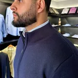 Campera tejida color marrón claro con cierre frontal, cuello alto y mangas largas con puños acanalados.