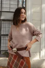 Buzo de lana color rosado, con cuello redondo, mangas largas y diseño holgado.