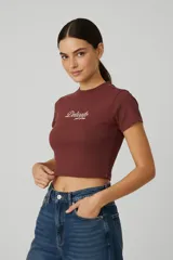 Top de algodón de corte ajustado, con cuello redondo, mangas cortas y estampa frontal con la frase 'Don't be jealous' en color bordó.