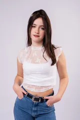 Polera cropped de encaje color bordó con diseño floral, cuello alto y mangas casquillo. Presenta una textura semitransparente y un ajuste entallado.