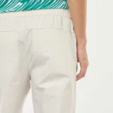 Pantalón de corte recto en color gris claro, confeccionado en tela de algodón, con cintura elástica y bolsillos laterales.