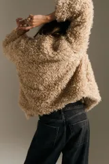 Jean de tiro alto con corte wide leg, confeccionado en denim rígido de color negro con efecto lavado. Presenta diseño clásico de cinco bolsillos, cierre frontal con cremallera y botón, y terminación de botamanga con ruedo desflecado.