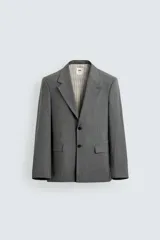 Blazer de corte regular confeccionada en tejido con lana, color gris. Presenta cuello con solapas de muesca, manga larga, bolsillos de vivo en el pecho y bolsillos de solapa en la cadera. Cuenta con cierre frontal de botones y aberturas en la espalda.