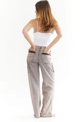 Pantalón jean de tiro alto color beige con efecto tie-dye azul.