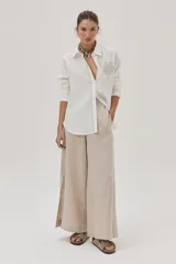 Camisa blanca de lino con bordados beige en la cartera y el bolsillo.