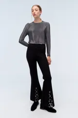 Remera plateada de lurex con escote redondo, calce al cuerpo y mangas largas estilo princesa.