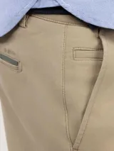 Pantalón chino de corte regular fit, confeccionado en gabardina con acabado desgastado. Presenta bolsillos laterales y traseros, con cierre de botón y cremallera.