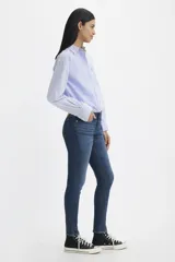 Jeans de tiro medio, color azul oscuro, de corte ajustado en cadera y muslos, y pierna skinny.