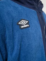 Campera de polar blanca con capucha y detalles en azul marino, con cierre frontal completo. Presenta el logo de Umbro y el escudo del Club Nacional de Football en el pecho.