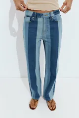 Jeans de tiro medio y pernera recta con diseño de rayas verticales en diferentes tonos de denim. Cuenta con cinco bolsillos y cierre frontal con cremallera y botón.