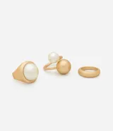 Set de tres anillos de metal con baño dorado. El kit incluye un anillo robusto con una perla artificial grande, un anillo abierto con una perla artificial mediana y un anillo minimalista de banda lisa.