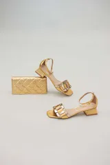 Cartera de cuero color marrón claro, con diseño capitoneado y cadena metálica plateada removible. Tiene ranuras interiores para tarjetas y documentos, y forro textil rojo.