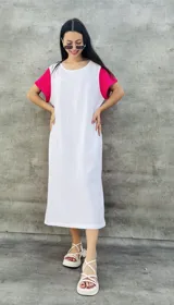 Vestido largo blanco con mangas cortas negras y corte holgado.