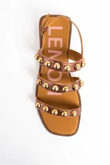 Sandalias planas Lemon de cuero color bronce, con tres tiras frontales adornadas con tachas semiesféricas doradas y cierre de hebilla ajustable en el talón.