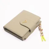 Billetera pequeña color verde con cierre de broche y cierre de cremallera. Incluye llavero decorativo con cuentas y borlas.