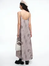 Vestido largo de breteles finos con escote en V, confeccionado en lyocell con estampa orgánica efecto lavado. Presenta una silueta levemente evasé con caída recta y fluida.