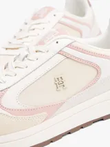 Zapatillas de corte bajo confeccionadas en ante con mezcla de texturas en tonos beige, crema y rosado. Presentan cierre de cordones, suela de EVA blanca con base de goma marrón, insignia con monograma TH en el lateral y logo de Tommy Hilfiger en bajo relieve en el talón.