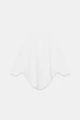 Camiseta tipo capa color blanco, confeccionada en algodón Supima®, de corte regular fit con escote en pico, manga larga fluida y bajo asimétrico.