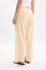 Pantalón casual de corte ancho, color amarillo claro, con cintura alta y detalle de lazo.