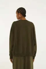Buzo verde militar de cuello redondo y manga larga, con estampa frontal de un tucán con lentes de sol y el texto "Farm Rio".