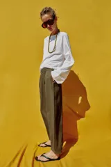 Pantalón de lino marrón oscuro, de corte barrel con pernera holgada que se estrecha hacia el tobillo, cintura elástica y bolsillos delanteros.