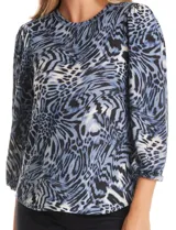 Buzo de tejido soft con estampado floral en tonos azules sobre base gris. Presenta cuello redondo, mangas largas con hombros ligeramente abullonados y puños fruncidos.