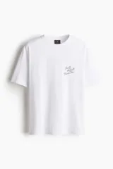 Remera blanca de punto de algodón, cuello redondo con ribete acanalado, hombros caídos y corte holgado. Cuenta con pequeño estampado tipográfico en el pecho con la inscripción "Puerto Vallarta Beach Bar".