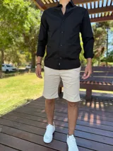 Camisa clásica negra de manga larga con botones frontales y cuello camisero.