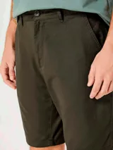 Bermuda recta estilo chino para hombre, confeccionada en lino color beige, con bolsillos laterales y traseros, y cierre frontal con botón y cremallera.