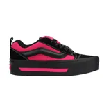 Championes Vans modelo Knu Stack, con diseño de plataforma alta en color negro y detalles en fucsia. Presentan la icónica banda lateral acolchada, cordones negros y construcción robusta.