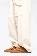 Zapatilla de perfil bajo confeccionada en serraje vacuno con estampado de manchas tipo animal print vacuno. Presenta cierre de cordones, detalle de piel en el talón con logo y suela de goma con textura de tachuelas.