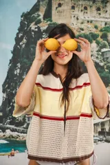 Remera de punto con diseño retro de bloques de color en marrón, crema y celeste. Presenta cierre frontal, cuello redondo, mangas cortas y tejido calado en la parte inferior. Incluye detalle de logo en relieve en el frente.