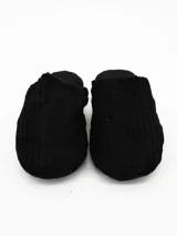 Pantuflas de estar por casa color negro, confeccionadas en tejido de pana con textura acanalada y suela plana.