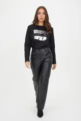 Pantalón de corte recto confeccionado en cuero sintético negro, con cierre frontal, botón y bolsillos laterales.