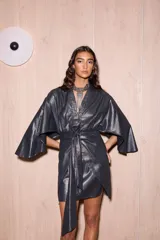 Vestido corto tipo kimono color gris metalizado, con mangas abiertas y amplias, escote en V y tiras ajustables para atar en la cintura.