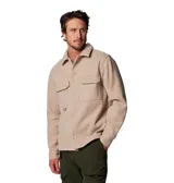 Campera tipo sobrecamisa Columbia de estilo retro, confeccionada en tejido de textura suave color beige. Presenta cierre frontal con botones, cuello clásico, dos bolsillos frontales con solapa y un anillo en D metálico en el bolsillo derecho. Incluye etiqueta de la marca en el bolsillo izquierdo.