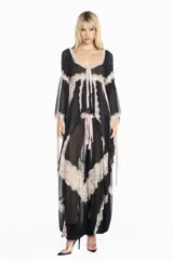 Bata de chiffon negro con mangas largas acampanadas, detalles de encaje beige en los bordes y lazos frontales. Presenta un diseño fluido y semitransparente.