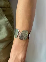 Pulsera de alpaca plateada, hecha a mano, con tres piezas irregulares unidas por barras horizontales.