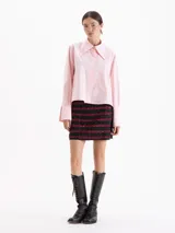 Camisa de poplín de algodón con corte holgado y largo hasta la cadera. Presenta cuello clásico con detalle de herraje metálico, cartera oculta con botones al tono y puños anchos con botones.