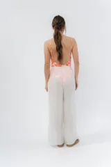 Pantalón ancho de gasa liviana color blanco, con cintura elástica y aberturas laterales decoradas con pompones.