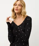 Pijama de dos piezas confeccionado en tejido rib acanalado con estampado floral. Incluye una blusa de manga larga con cuello redondo y cierre frontal de botones, y un pantalón largo con cintura elástica.