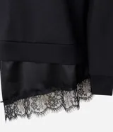 Buzo de algodón con felpa, corte oversized, cuello redondo y mangas largas. Presenta un detalle de encaje aplicado en el ruedo, aportando un contraste femenino y sofisticado.