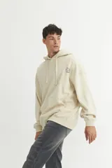 Canguro azul con capucha forrada, cordones de algodón y ojalillos metálicos. Tiene un calce oversize y un pequeño logo estampado en el pecho.